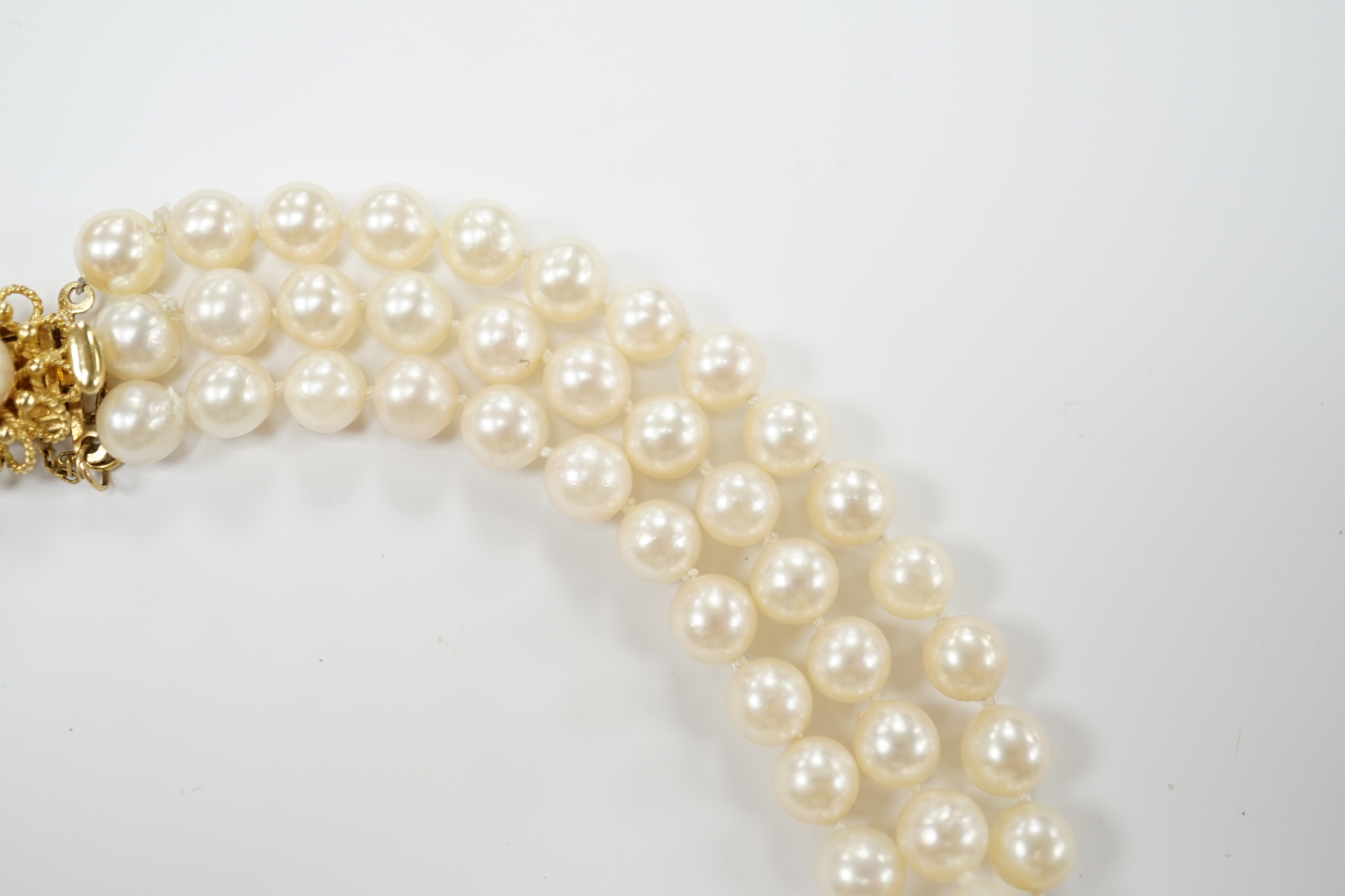 A triple strand cultured pearl set choker necklace, with 750 yellow metal and cultured pearl set clasp, 35cm.